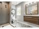 Well-lit bathroom with glass shower, patterned tile floor, and floating wood vanity at 654 E 79Th St, Indianapolis, IN 46240