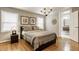 Charming bedroom with warm wood floors, stylish chandelier, and view of ensuite bathroom at 654 E 79Th St, Indianapolis, IN 46240