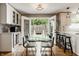 Bright dining room with modern table, hardwood floors, and French doors leading to patio at 654 E 79Th St, Indianapolis, IN 46240