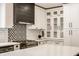 Modern kitchen features stainless steel gas range, white cabinetry, and mosaic backsplash at 654 E 79Th St, Indianapolis, IN 46240