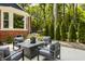 Backyard patio featuring cushioned seating and a view of lush trees creating a tranquil outdoor space at 654 E 79Th St, Indianapolis, IN 46240