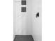 Modern walk-in shower featuring white tile, black fixtures and black honeycomb tile floor at 654 E 79Th St, Indianapolis, IN 46240