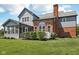 Backyard featuring gray siding, brick chimney, arched window and inviting screened-in porch with greenery in foreground at 7323 Elm Ridge Dr, Indianapolis, IN 46236