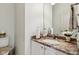 Bright bathroom featuring vanity with granite countertop, undermount sink, white cabinets, and a framed mirror at 7323 Elm Ridge Dr, Indianapolis, IN 46236