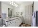 Bathroom showcasing double sinks, granite countertops, white cabinets, and ample lighting from a multi-bulb fixture at 7323 Elm Ridge Dr, Indianapolis, IN 46236