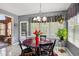 Cozy dining area offers natural light through large windows and features a chandelier above a round dining table at 7323 Elm Ridge Dr, Indianapolis, IN 46236