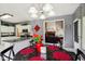 Open dining area with black table, red accents, and chandelier, flowing into the kitchen and living room at 7323 Elm Ridge Dr, Indianapolis, IN 46236
