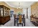 Formal dining room with a traditional china cabinet, dining set and crown molding at 7323 Elm Ridge Dr, Indianapolis, IN 46236