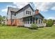 Detailed view of home's exterior, highlighting the gray siding, brick accents, screened-in porch, and manicured landscaping at 7323 Elm Ridge Dr, Indianapolis, IN 46236