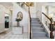 Welcoming foyer with staircase, decorative mirror, and tile flooring at 7323 Elm Ridge Dr, Indianapolis, IN 46236