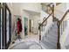 Elegant foyer with staircase, tiled floors, and coat closet at 7323 Elm Ridge Dr, Indianapolis, IN 46236