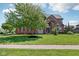 Charming brick home featuring a landscaped yard and mature tree, showcasing curb appeal at 7323 Elm Ridge Dr, Indianapolis, IN 46236