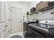Laundry room showcasing modern washer and dryer, white cabinetry, and convenient overhead shelving for storage at 7323 Elm Ridge Dr, Indianapolis, IN 46236