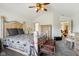 Bedroom with a wooden bed frame, vaulted ceiling, large window, carpet, and entry into another room at 7323 Elm Ridge Dr, Indianapolis, IN 46236