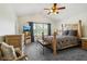 Bedroom with a wooden bed frame, vaulted ceiling, large window, ceiling fan, and gray carpet at 7323 Elm Ridge Dr, Indianapolis, IN 46236
