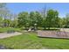 A well-maintained playground with a slide, swings, and picnic table surrounded by lush green grass and mature trees at 7323 Elm Ridge Dr, Indianapolis, IN 46236