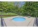 Inviting small pool with clear blue water and lounge chairs, surrounded by a black fence at 7323 Elm Ridge Dr, Indianapolis, IN 46236