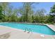 Community pool with clear water, lounge chairs, and umbrellas on a sunny day at 7323 Elm Ridge Dr, Indianapolis, IN 46236