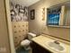Compact bathroom with decorative tile accents, a vanity sink, and a toilet, optimizing space and functionality at 7334 E 14Th St, Indianapolis, IN 46219