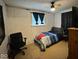 A modest bedroom featuring a ceiling fan, a window with blue curtains, and simple furnishings at 7334 E 14Th St, Indianapolis, IN 46219