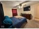 A standard bedroom includes a ceiling fan, TV, dresser, bed with an American flag blanket, and beige walls at 7334 E 14Th St, Indianapolis, IN 46219