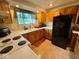 Well-lit kitchen with oak cabinets, black appliances, and a cozy atmosphere for preparing delicious meals at 7334 E 14Th St, Indianapolis, IN 46219