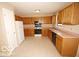 Traditional kitchen with wood cabinets, tile flooring, and a white refrigerator at 7450 Cobblestone W Dr, Indianapolis, IN 46236