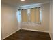 Bedroom features neutral walls, dark wood floors, and curtained window at 823 N Noble St, Greenfield, IN 46140