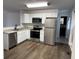 Well-lit kitchen featuring stainless steel appliances, white cabinetry, and granite countertops at 823 N Noble St, Greenfield, IN 46140