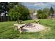 Landscaped backyard featuring a fire pit surrounded by wooden benches, perfect for outdoor gatherings and entertainment at 8232 N Chaucer Ct, Columbus, IN 47201