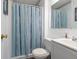 Bathroom with white single sink vanity, framed mirror, and shower with striped curtain at 8232 N Chaucer Ct, Columbus, IN 47201
