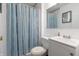 Bathroom with white single sink vanity, framed mirror, and shower with striped curtain at 8232 N Chaucer Ct, Columbus, IN 47201