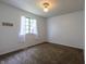 Bedroom featuring carpeted floors, one window with sheer curtains, and fresh white paint at 8232 N Chaucer Ct, Columbus, IN 47201