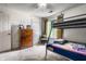 Cozy bedroom featuring a bunk bed, dresser, and large window for natural light at 8911 Hunters Creek Dr # 311, Indianapolis, IN 46227