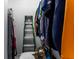 Organized walk-in closet with clothes, ladder, and storage boxes to maximize space at 8911 Hunters Creek Dr # 311, Indianapolis, IN 46227