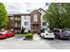 Condo's attractive exterior with brick accents, upper-level balconies, ample parking, and mature trees at 8911 Hunters Creek Dr # 311, Indianapolis, IN 46227