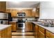 Well-lit kitchen featuring stainless steel appliances, ample wooden cabinetry and tiled backsplash at 8911 Hunters Creek Dr # 311, Indianapolis, IN 46227