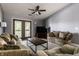 Comfortable living room with balcony access, featuring cozy seating, ceiling fan, and neutral decor at 8911 Hunters Creek Dr # 311, Indianapolis, IN 46227