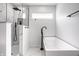 Contemporary bathroom with a soaking tub and walk-in shower featuring sleek black fixtures and white marble tile at 8966 Wooster Ct, Fishers, IN 46038