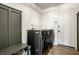 Well-lit laundry room features modern black washer and dryer with convenient storage and stylish design at 8966 Wooster Ct, Fishers, IN 46038