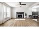 Spacious living room with a fireplace, modern flooring, a ceiling fan, and bright natural light at 8966 Wooster Ct, Fishers, IN 46038