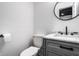 Stylish powder room features a gray vanity with marble countertop, modern black faucet, and round mirror at 8966 Wooster Ct, Fishers, IN 46038