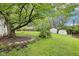 Landscaped backyard featuring mature trees, green lawn, and utility sheds offering a private outdoor space at 90 S Morgantown Rd, Greenwood, IN 46142