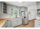 A kitchen view showcasing stainless steel appliances, light green cabinets, and butcher block countertops at 90 S Morgantown Rd, Greenwood, IN 46142