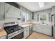 This kitchen includes light green cabinetry, a stainless steel range, and butcher block countertops at 90 S Morgantown Rd, Greenwood, IN 46142