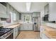 Light green kitchen with butcher block countertops, stainless steel appliances, and light wood floors at 90 S Morgantown Rd, Greenwood, IN 46142