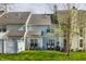 Back exterior view of the townhome showing large backyard, patio area, and mature landscaping at 9575 Thradd St, Fishers, IN 46038