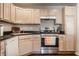 Modern kitchen with stainless steel appliances, light wood cabinets, and dark countertops at 9575 Thradd St, Fishers, IN 46038