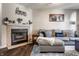 Cozy living room featuring a fireplace, gray sofa, and decorative wall art at 9575 Thradd St, Fishers, IN 46038