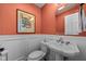 Charming powder room with a pedestal sink, wainscoting, and elegant decor at 9626 Oakhaven Ct, Indianapolis, IN 46256